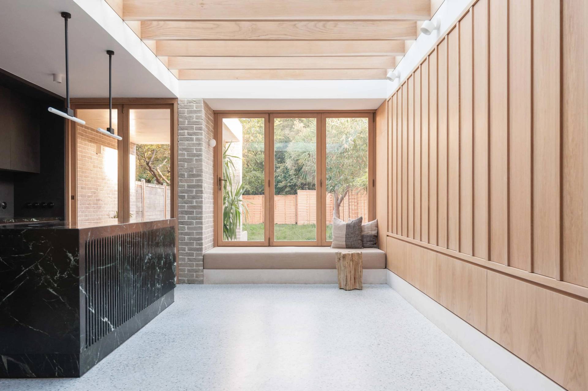 Sunlit open-plan seating area film location in Hackney London N16 through Love Locations, featuring light wood wall cladding, exposed timber rafters, and wide picture windows.