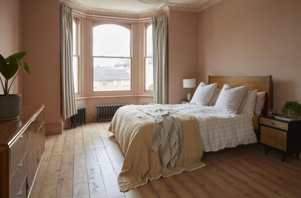 clay/ plaster pink bedroom - very light, bay window and upholstered bed.