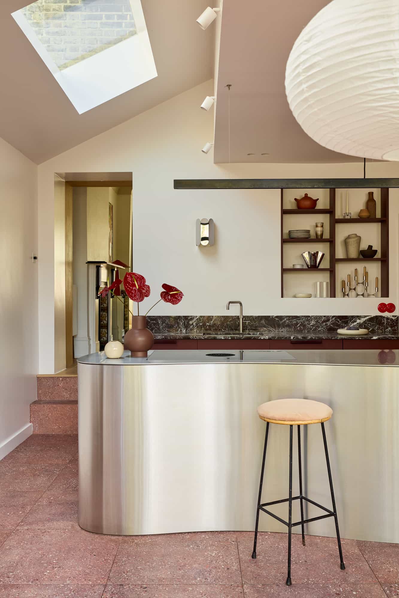 yon – Love Locations. Sophisticated Victorian home renovation with a serene palette, featuring a metal-sculpted kitchen island and contemporary wooden shelving that blends period charm with modern design