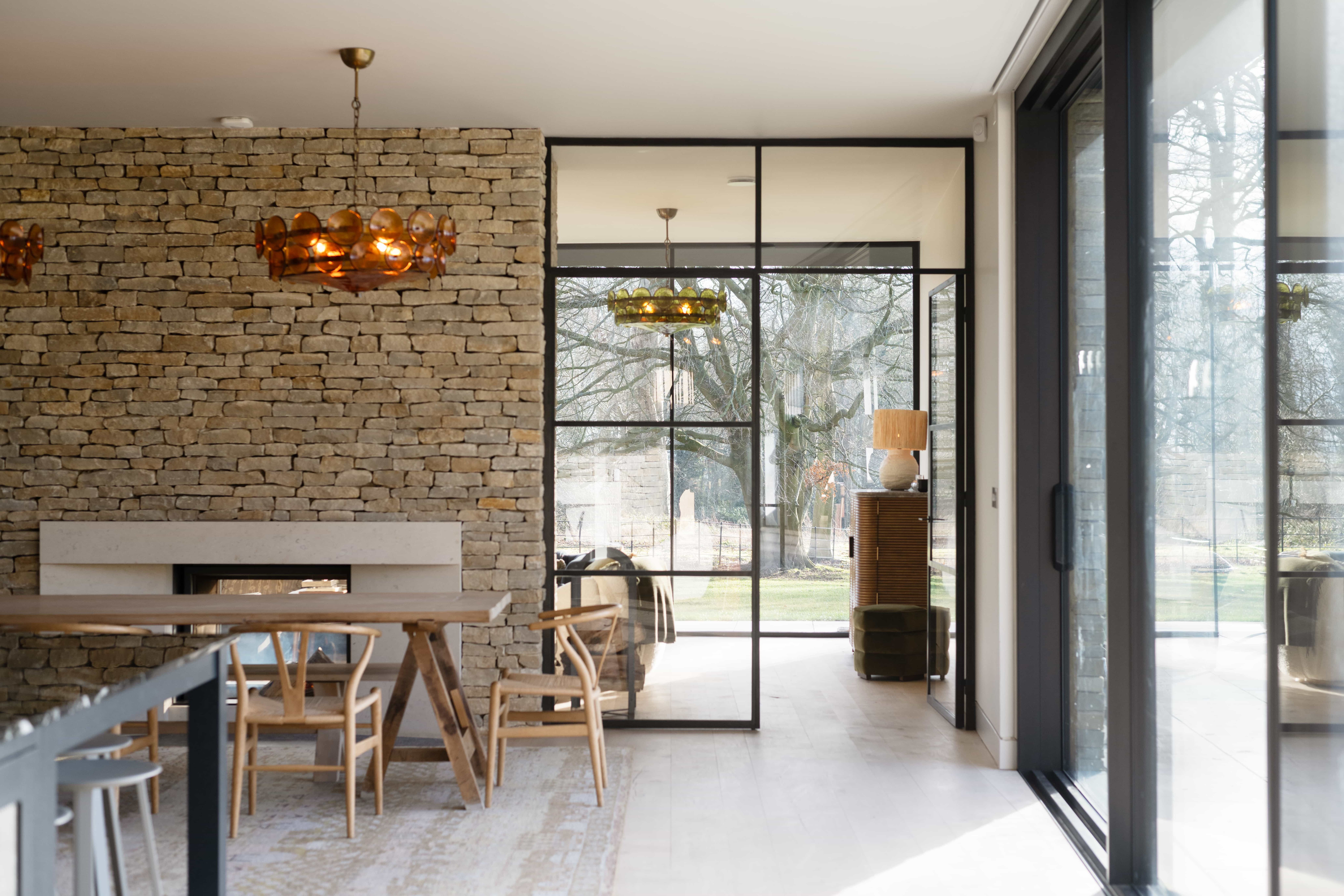 Black wood house- Love Locations- interior natural stone texture wall, black crittel windows