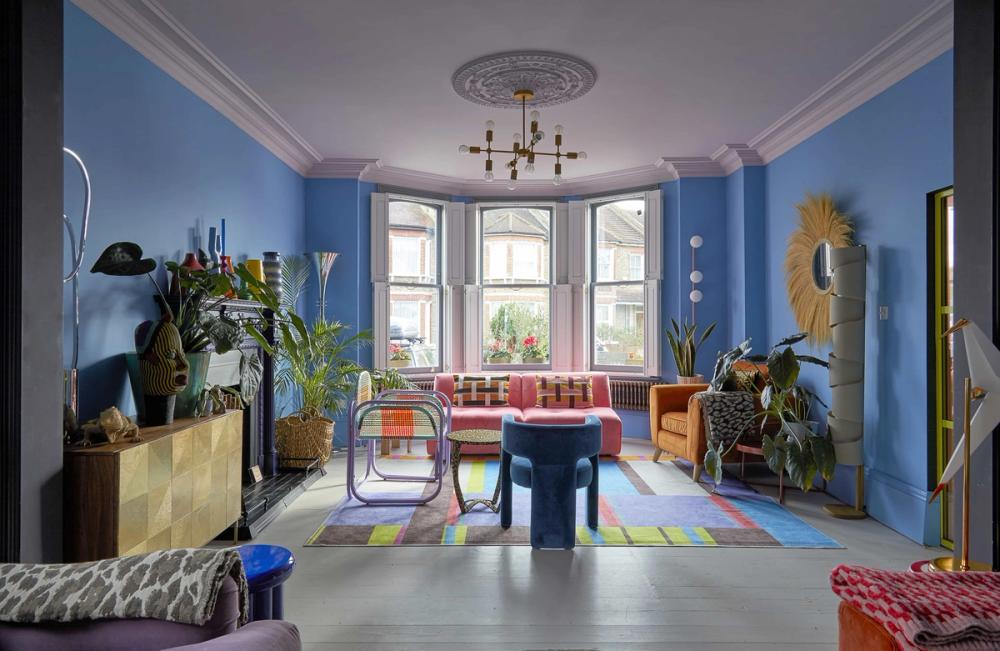 Chalky blue room , baywindow, modern statement sofa and chairs, pink & orange- colourful vibe