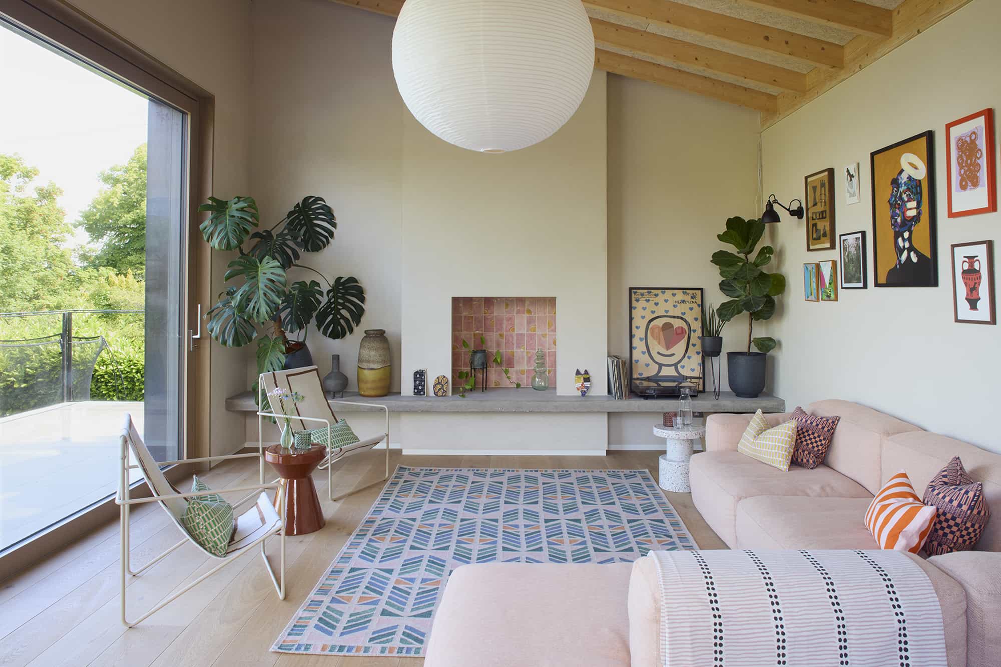 Spacious modern rustic interior with open fireplace, low seating, and a neutral contemporary rug