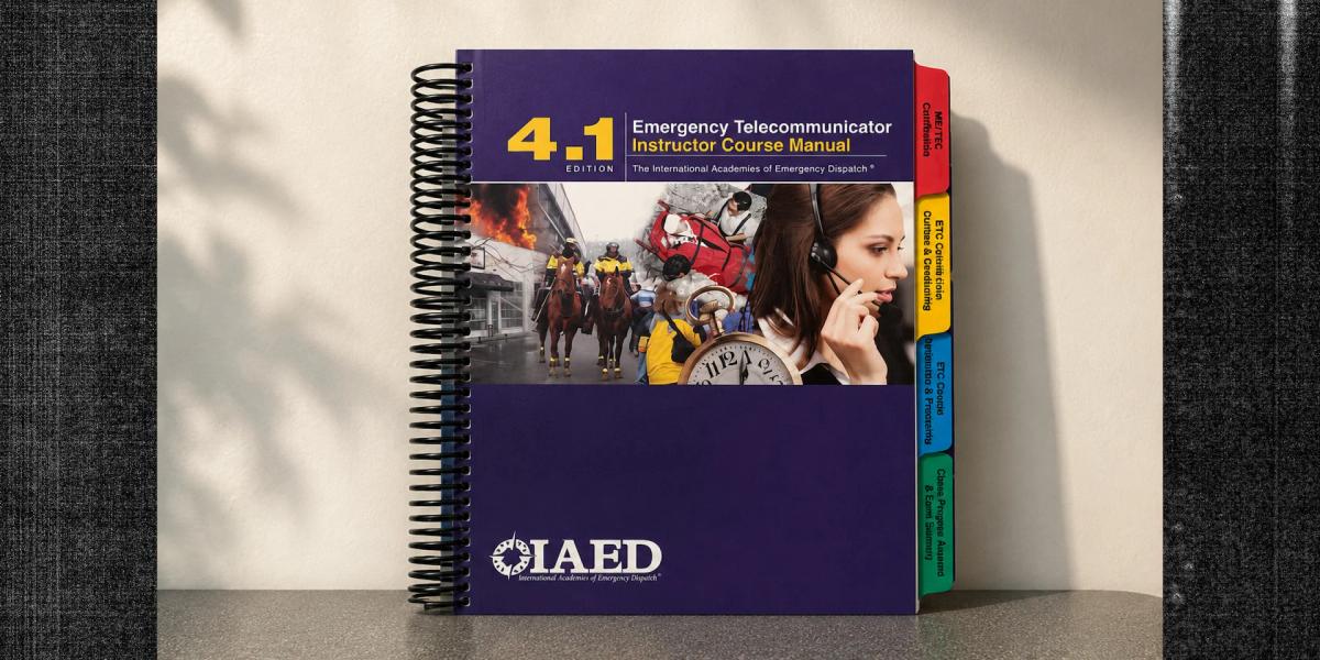 Spiral-bound course training manual with color-coded index tabs displayed on a tabletop.