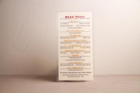Full view of the Porcupine beer menu against a plain wall, showing the tap list and the notes about growlers to go and 50-cent samplers.