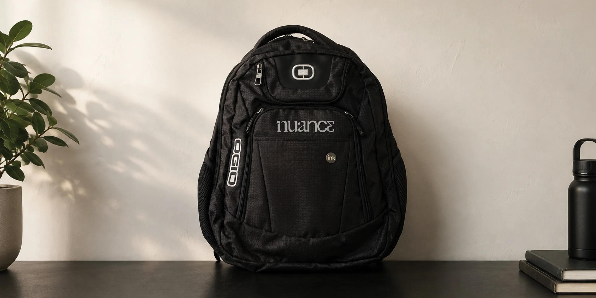 Branded black backpack displayed as a custom promotional product on a tabletop.