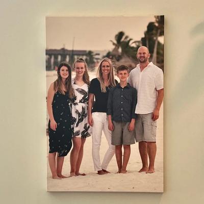 Large family portrait printed on a canvas wall display in a home.