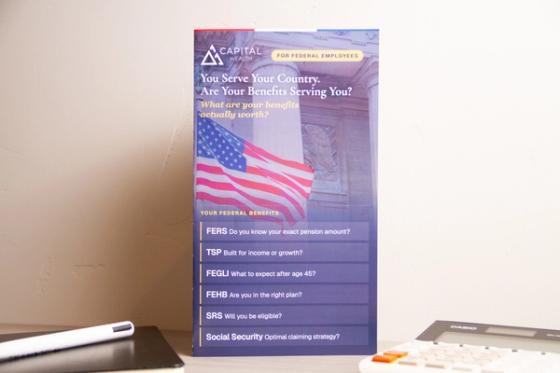 Capital Wealth brochure standing upright, showing the flag cover, the "For Federal Employees" badge and the benefits question list.