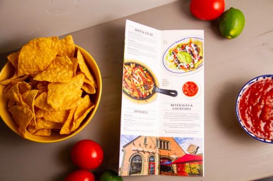 Overhead of an interior panel listing soups, salads, desserts and beverages, with a photo of the restaurant's historic brick firehouse home at the base.