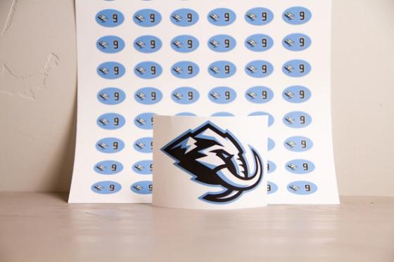  Full sheet of oval number 9 labels standing upright behind a single curled Utah Mammoth logo decal.