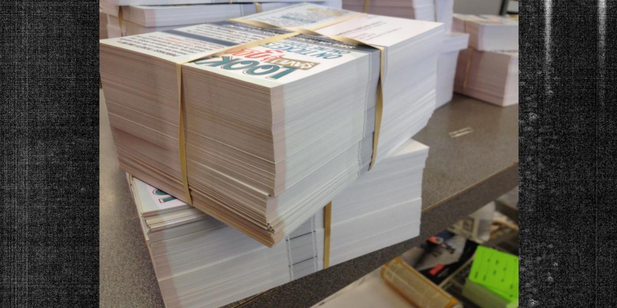 Stacks of bundled printed postcards ready for mailing and direct mail distribution.