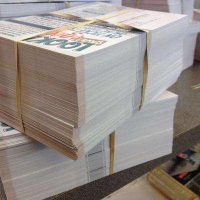 Stacks of bundled printed postcards ready for mailing and direct mail distribution.