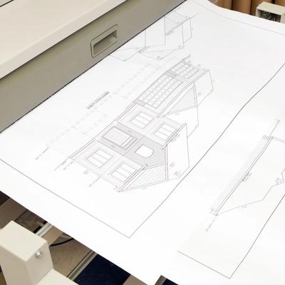 Large-format scanner digitizing oversized architectural blueprints and engineering drawings.