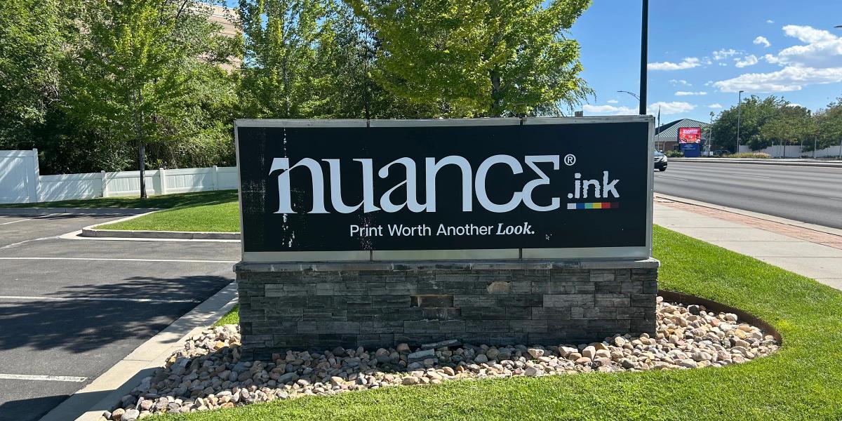 Monument sign with a printed adhesive-backed textile adhered.