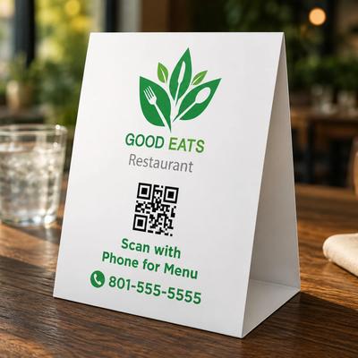 Custom printed table tent with QR code, branding, and promotional information displayed on a restaurant table.