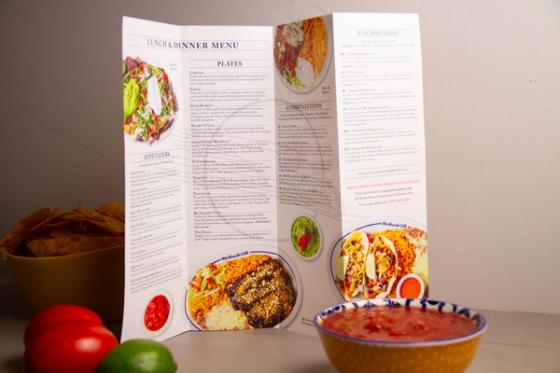 Mailer opened upright showing menu panels for appetizers, plates, combinations and enchiladas with plated food photography.