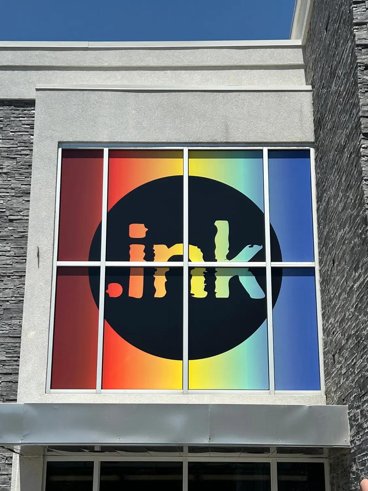 Custom exterior window graphics featuring a full-color branded design installed on a commercial building façade.