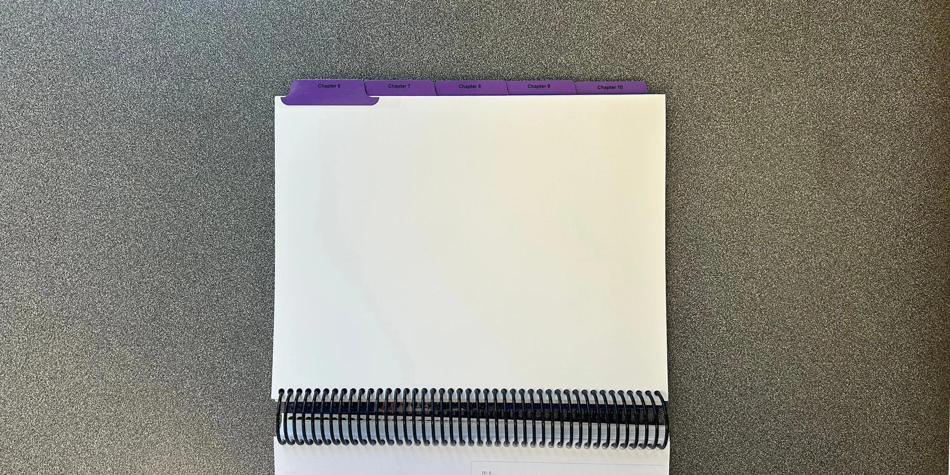 Spiral-bound presentation booklet with custom printed index tabs for organized document navigation.