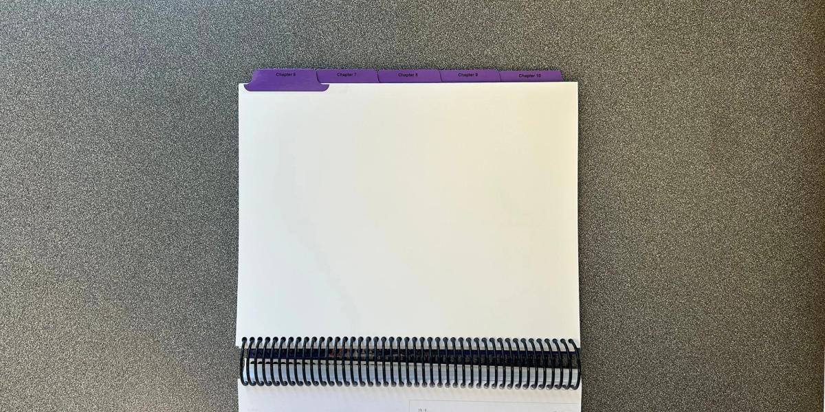 Spiral-bound presentation booklet with custom printed index tabs for organized document navigation.