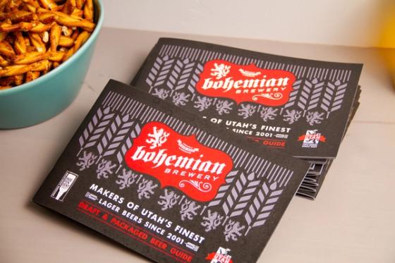 Two Bohemian Brewery beer guide booklets angled across each other, showing the red crest logo and wheat-and-lion cover pattern.