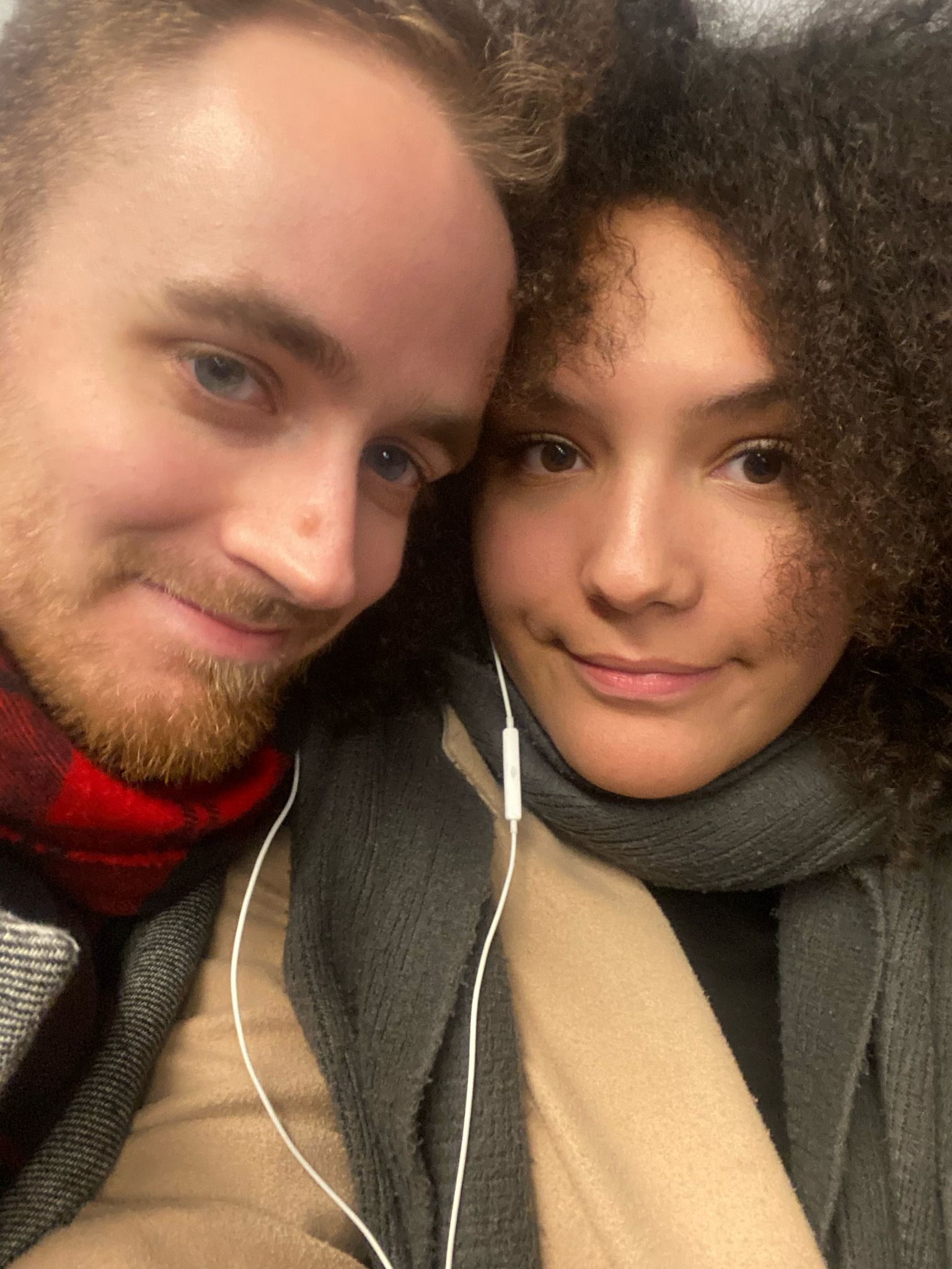 A woman posing on a balcony with a view of a lake