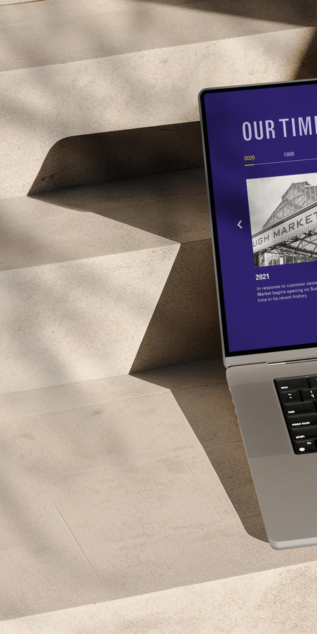 Borough Market website on a laptop, showing the "Our timeline" section with archive photos of the market