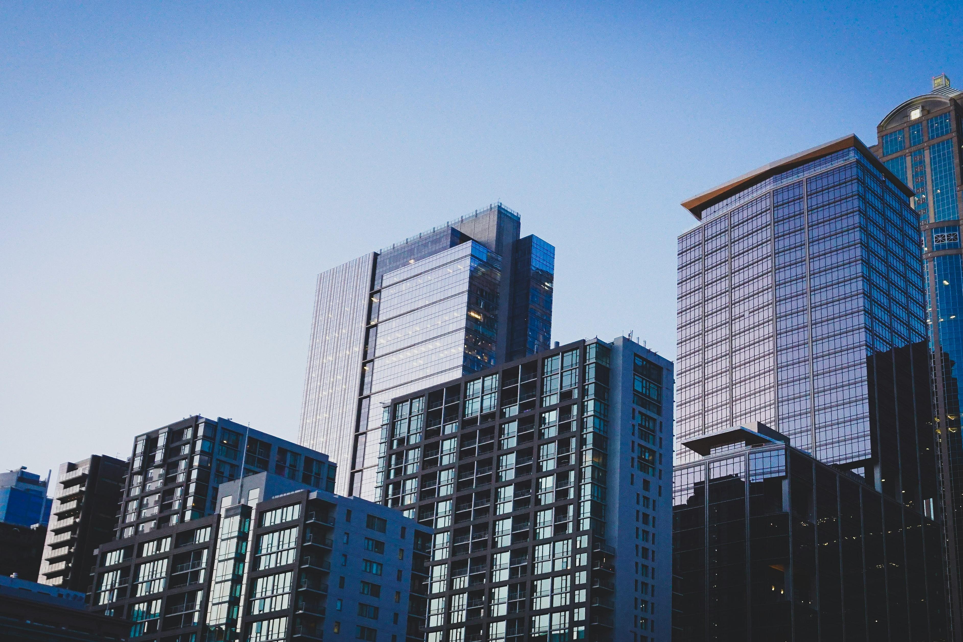 Glass office and residential towers against a clear blue evening sky