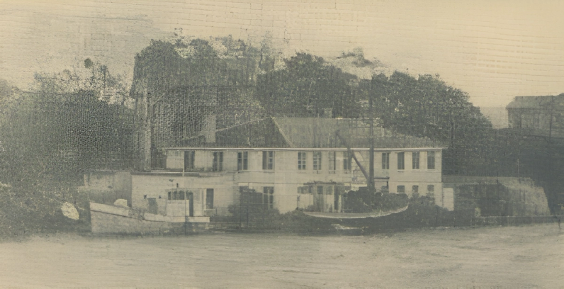 Gammelt bilde av to skøyter foran fabrikkbygning