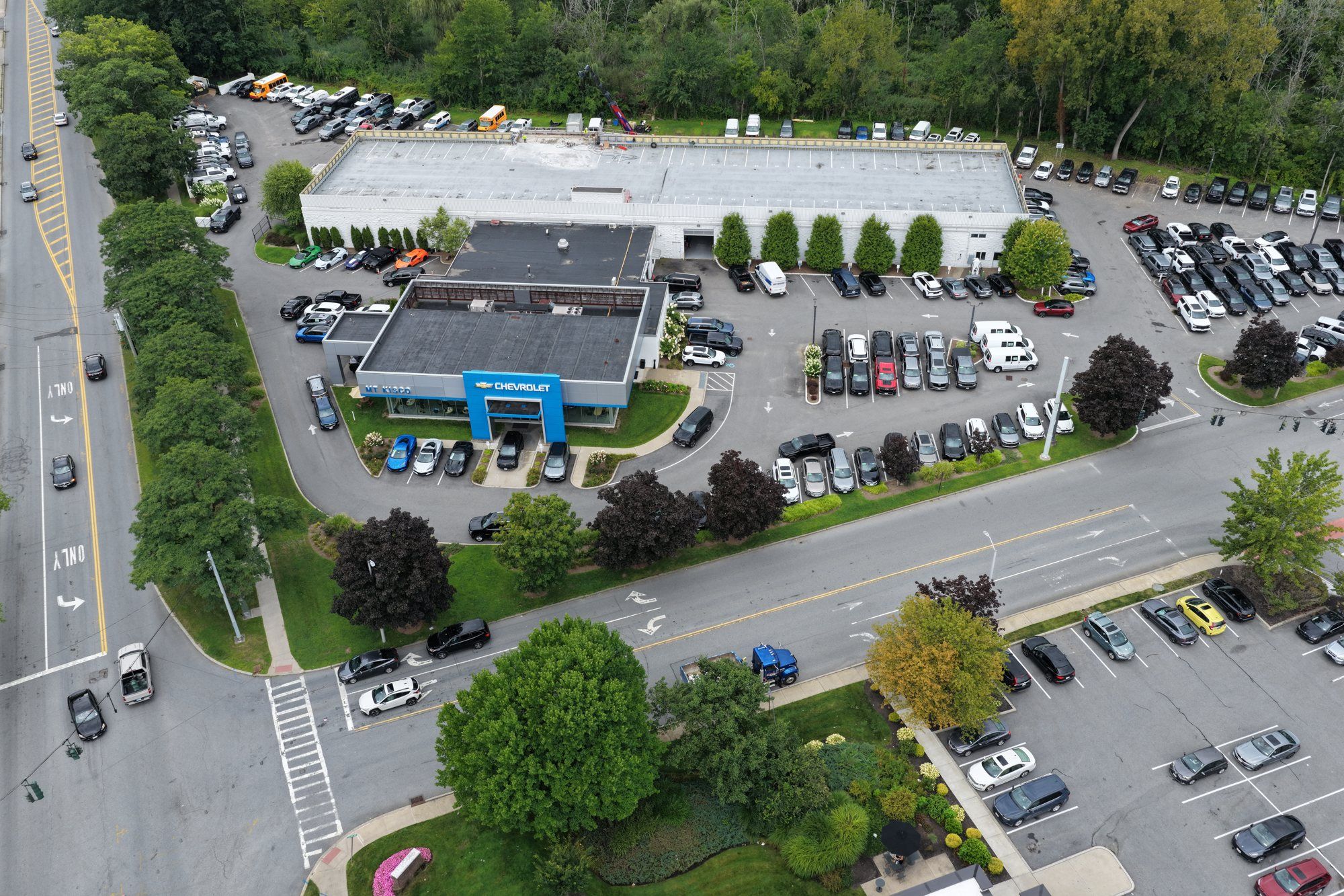 The dealership stayed fully open — showroom, service drive and rooftop parking all in use while the ramp was rebuilt