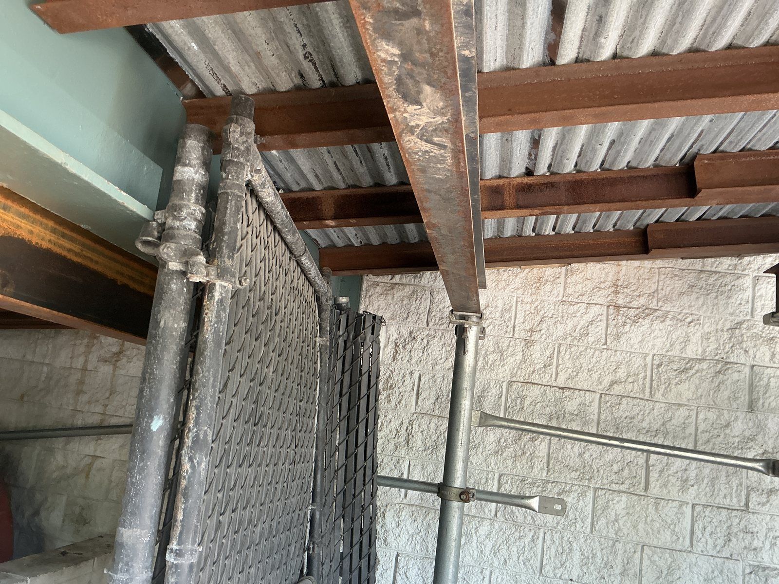 Overhead protection installed beneath the ramp before demolition, keeping the space below operational