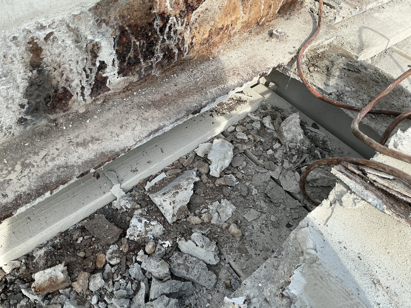 Deteriorated concrete and corroded embedded steel — the condition that drove the reconstruction