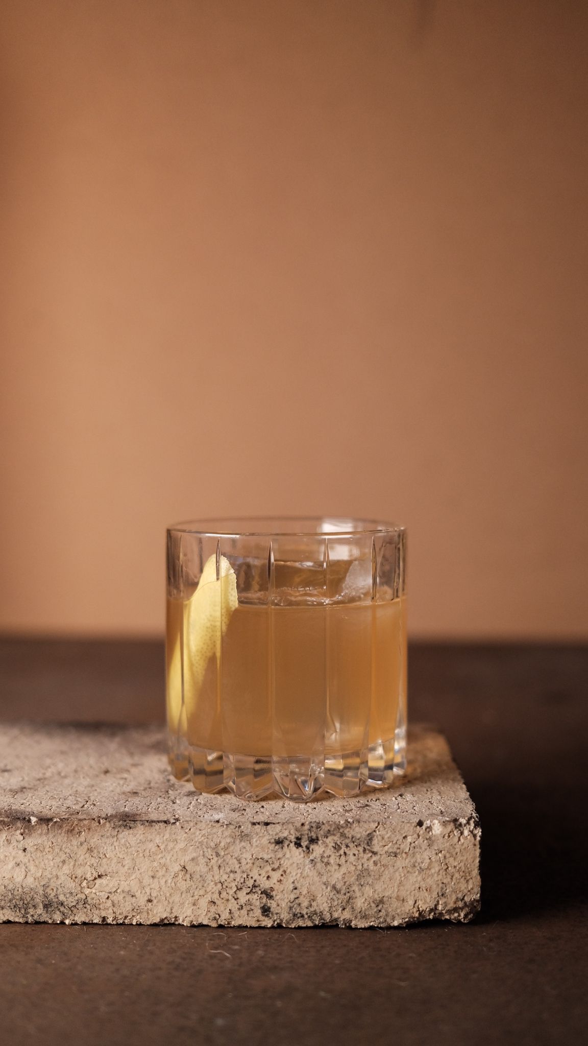 Drinken old honey i ett rocksglas med en skiva citron och en stor isbit.