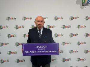 Luis Gallegos, President Boards of UNITAR, holding the Purple Economy Movement Pledge
