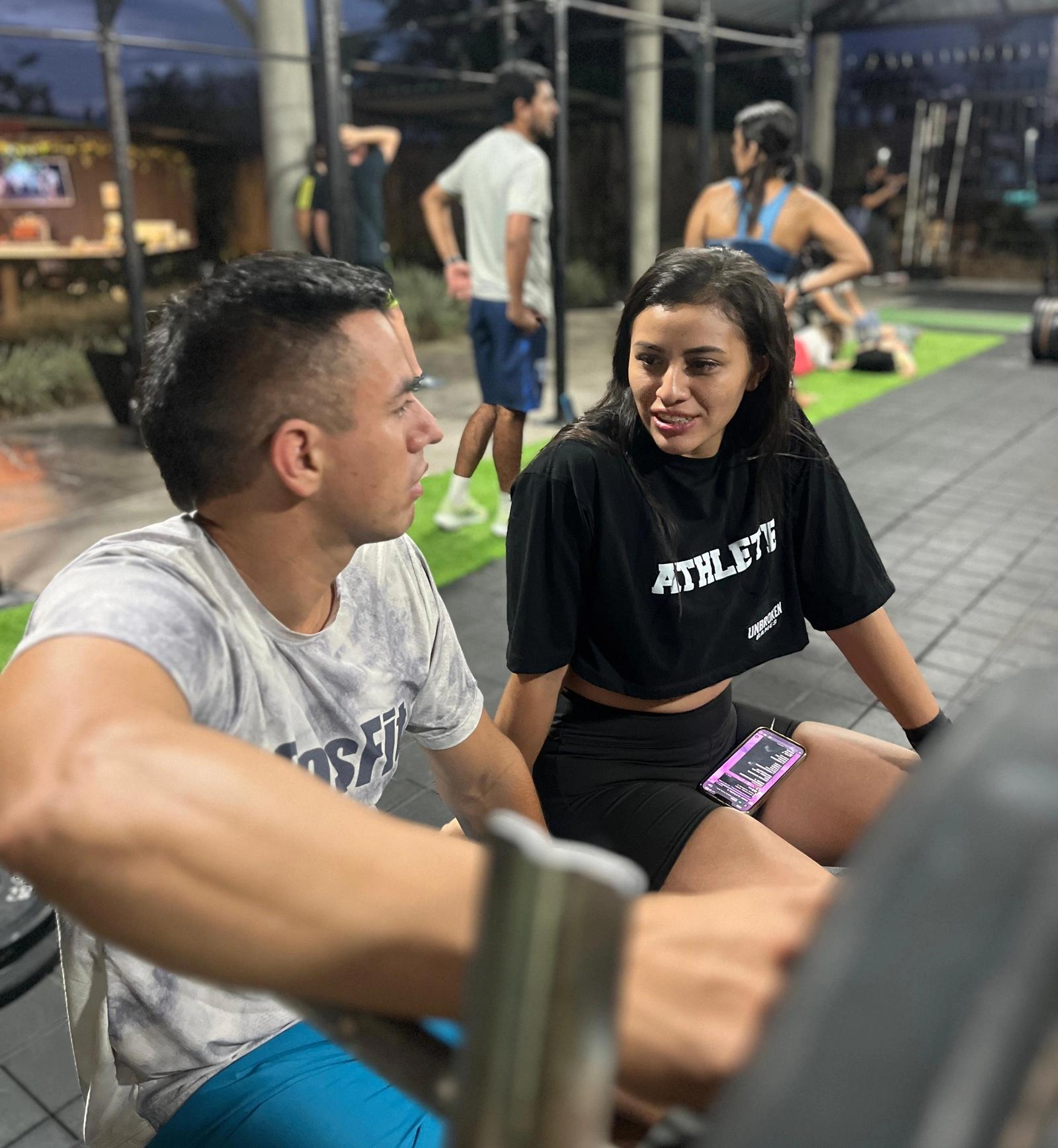 Dos personas entrenando juntas en un box de CrossFit