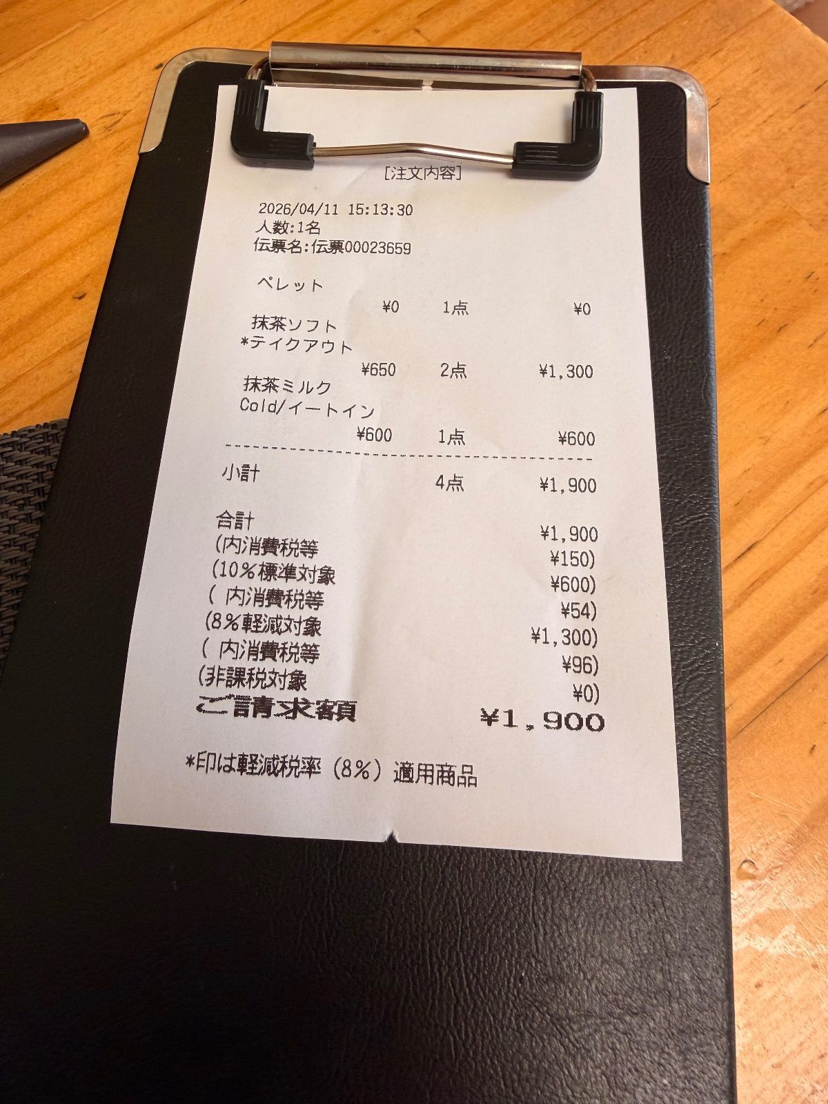 Cafe order slip showing matcha soft serve marked as takeout taxed at 8 percent and matcha milk marked eat-in taxed at 10 percent on the same 1,900 yen bill