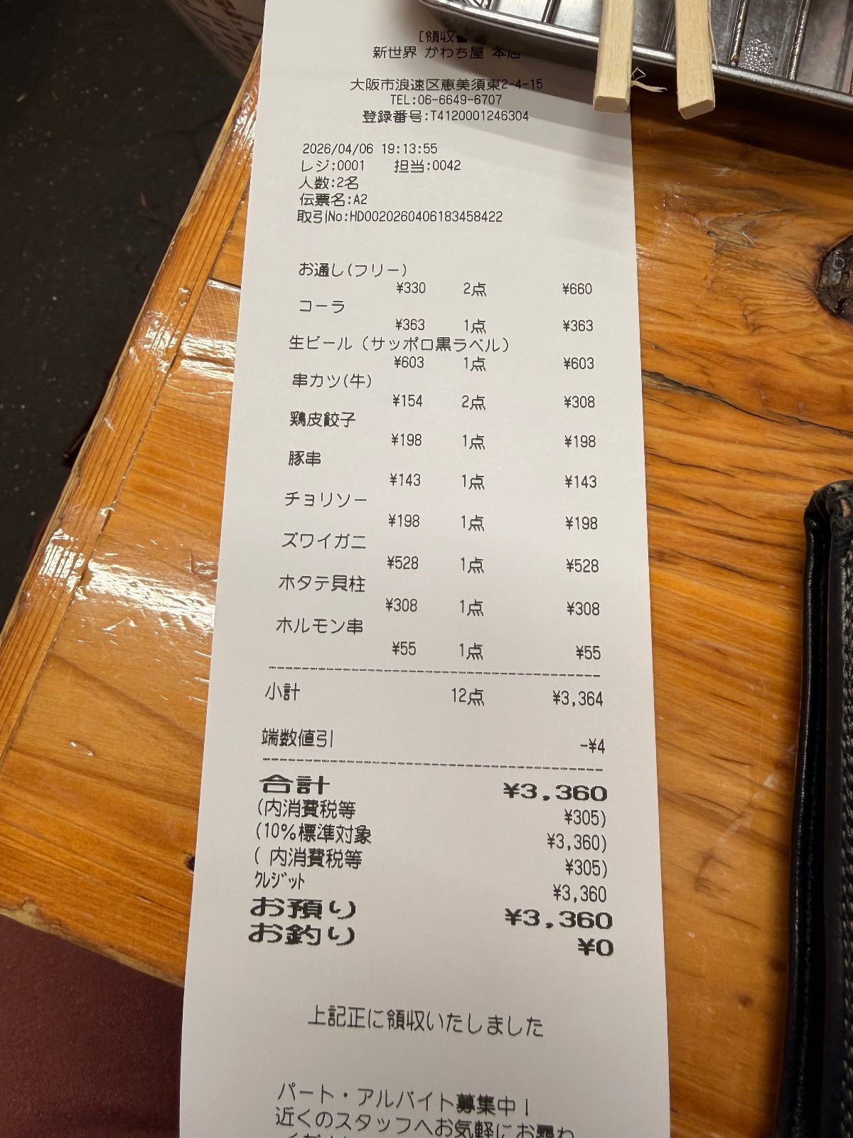 Itemised receipt from a kushikatsu bar in Shinsekai, Osaka, showing an otoshi seating charge of 330 yen for two people, twelve skewers and drinks, and a 4 yen rounding discount