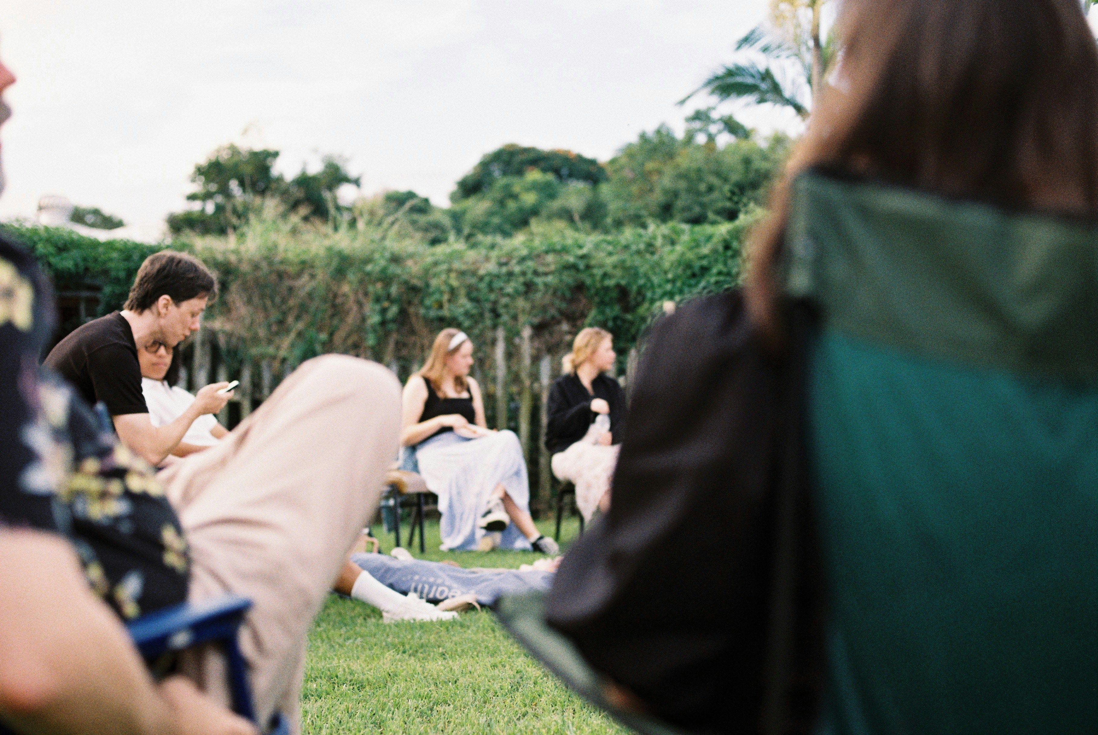 Team meeting during offsite sitting in camping chairs on a lawn