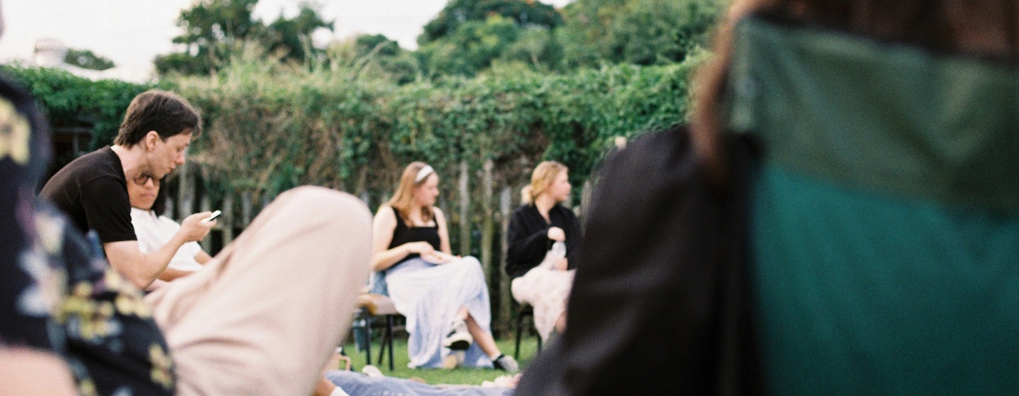 Team meeting during offsite sitting in camping chairs on a lawn
