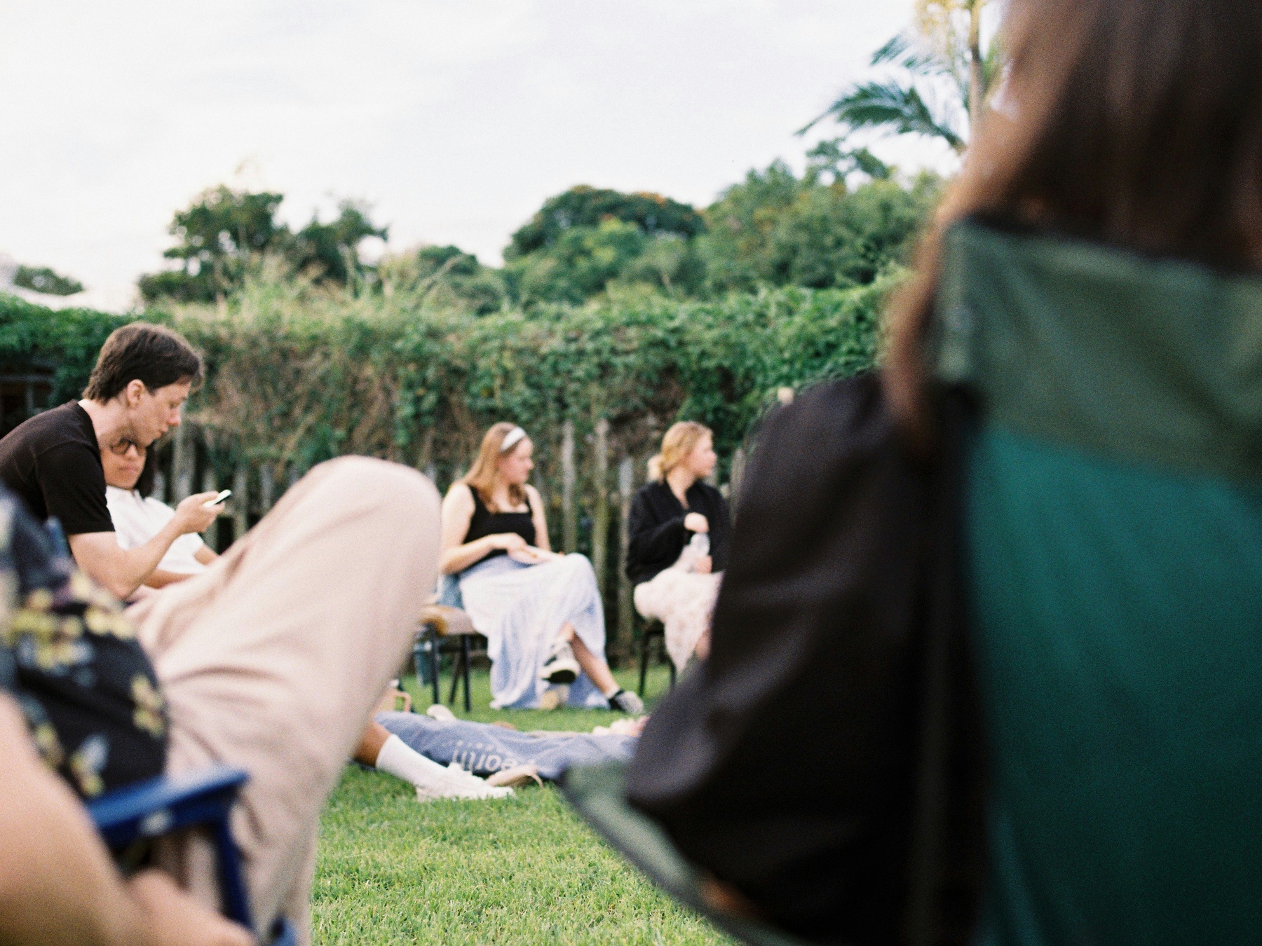 Team meeting during offsite sitting in camping chairs on a lawn