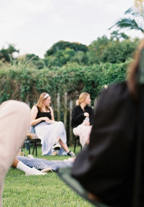 Team meeting during offsite sitting in camping chairs on a lawn