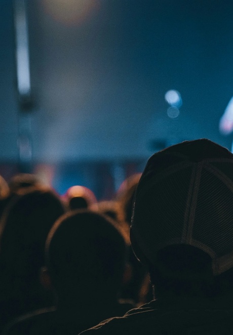 Attendees pay attention to a speaker on the main stage of a conference.