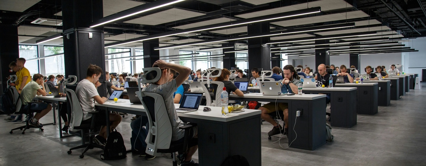 Open floor plan office full of workers at their desks