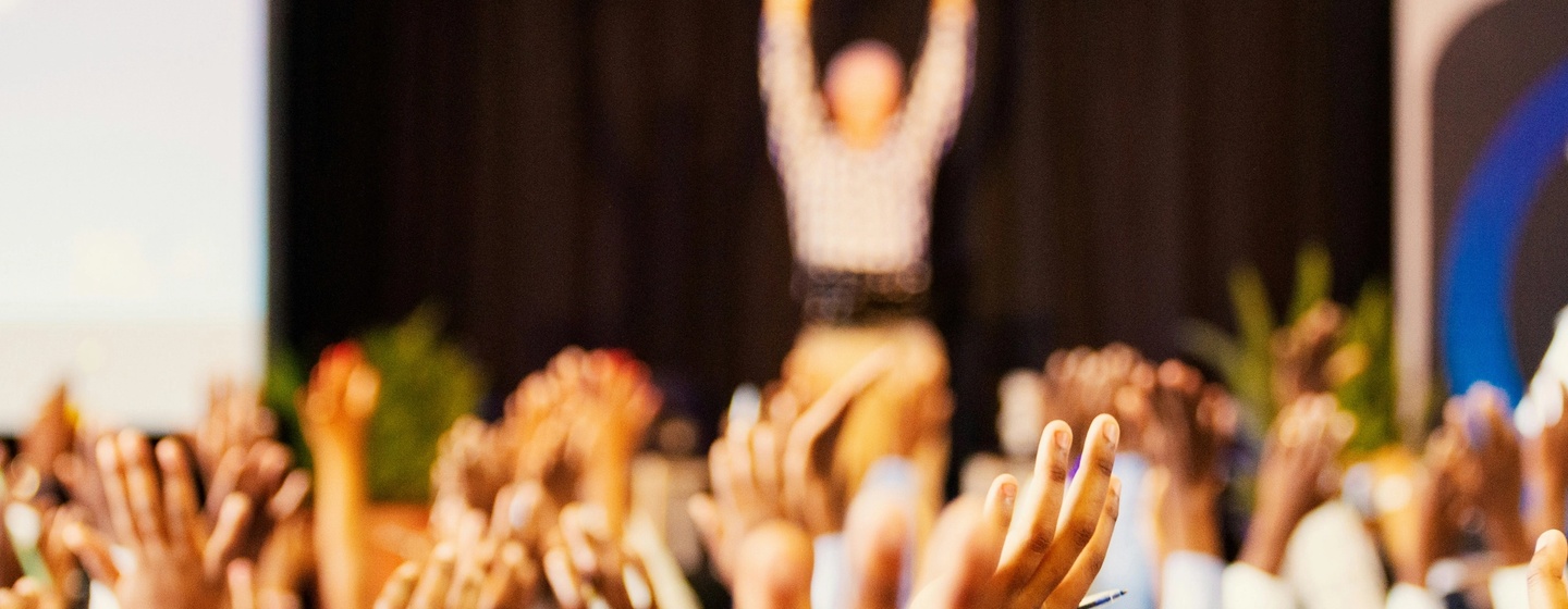 people raising hands at a conference