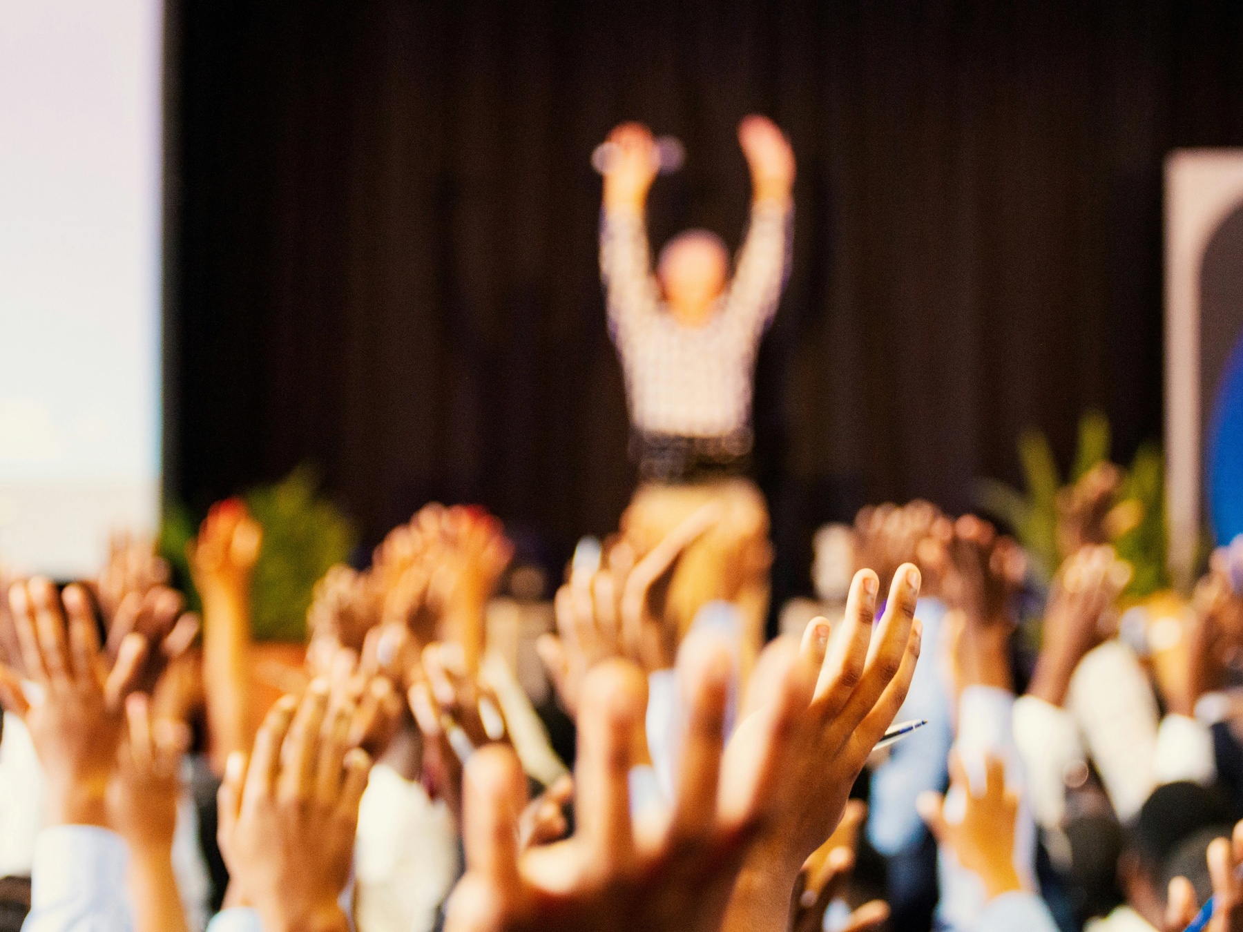 people raising hands at a conference