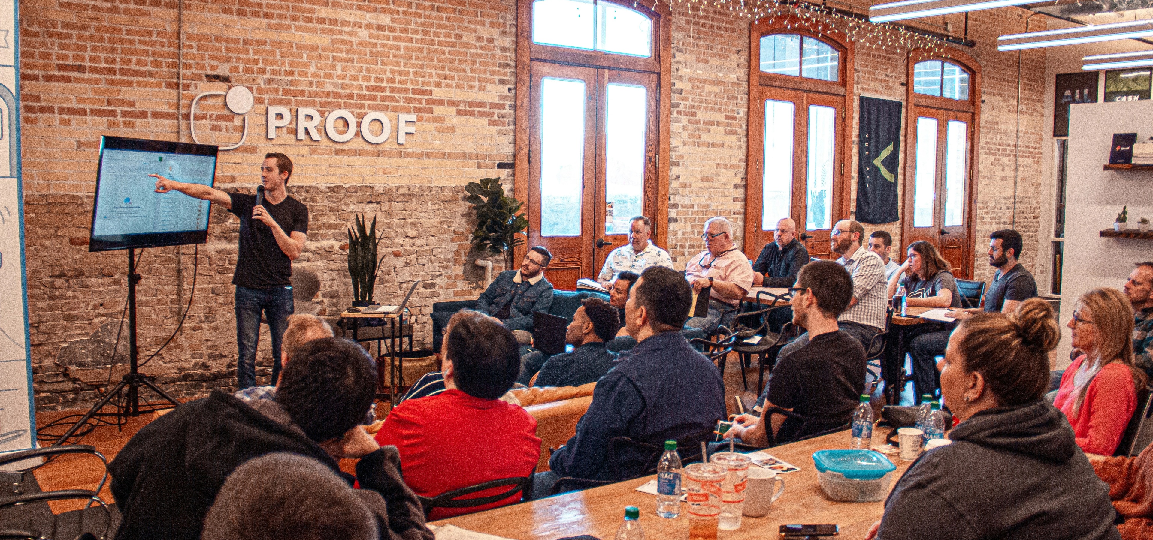 Man presenting slides to sales kickoff in start-up office for useproof.com.