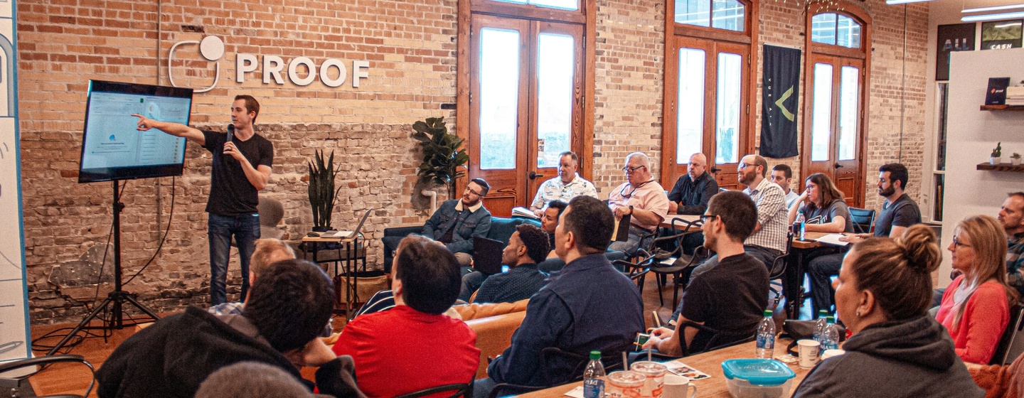 Man presenting slides to sales kickoff in start-up office for useproof.com.