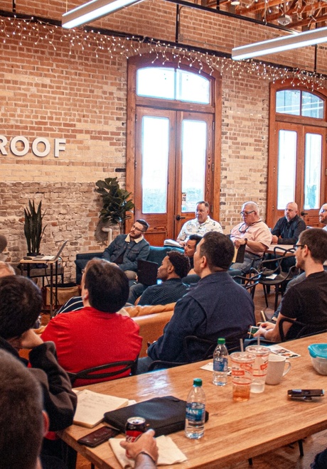 Man presenting slides to sales kickoff in start-up office for useproof.com.