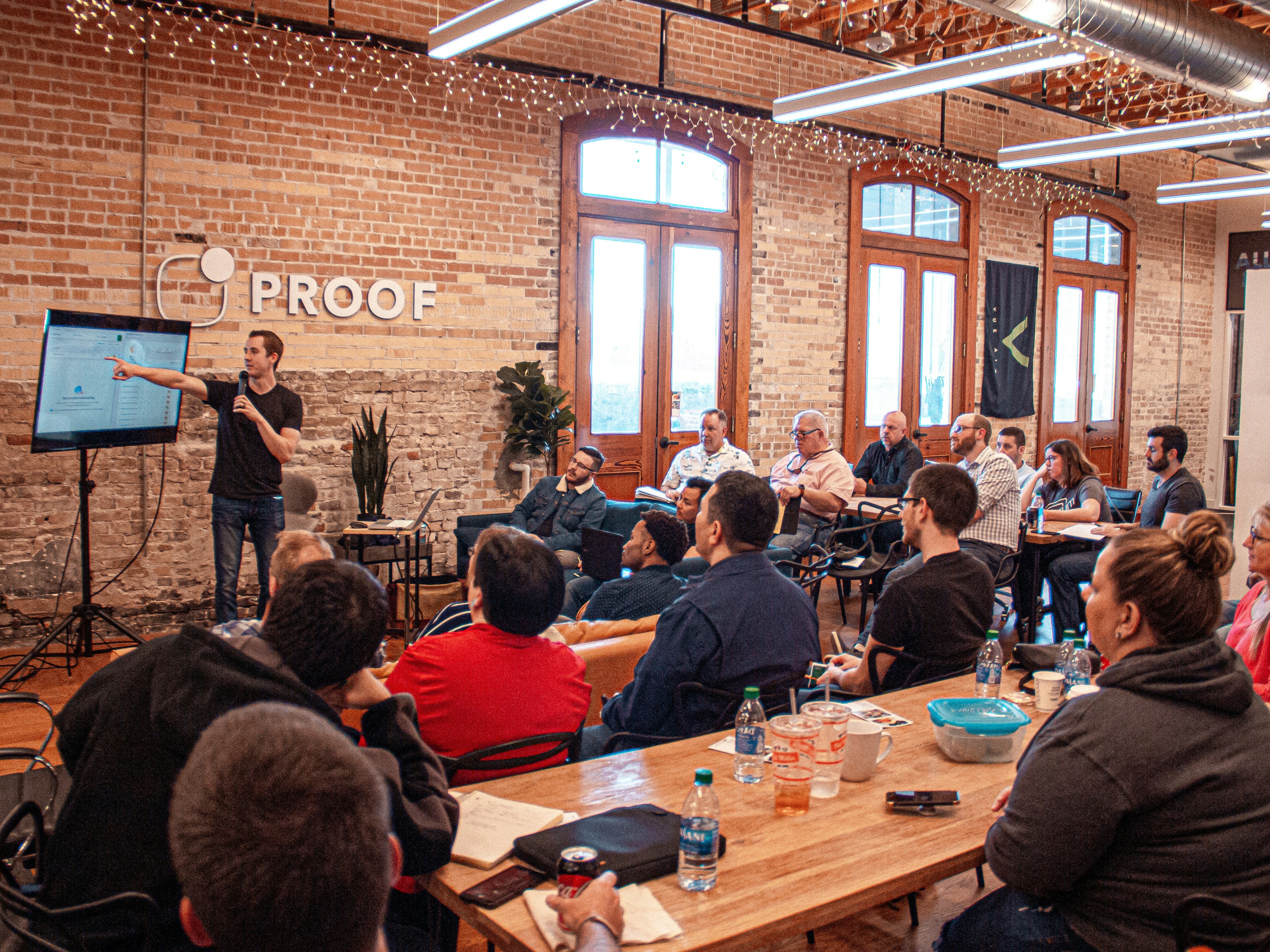 Man presenting power point to small audience in start-up office.