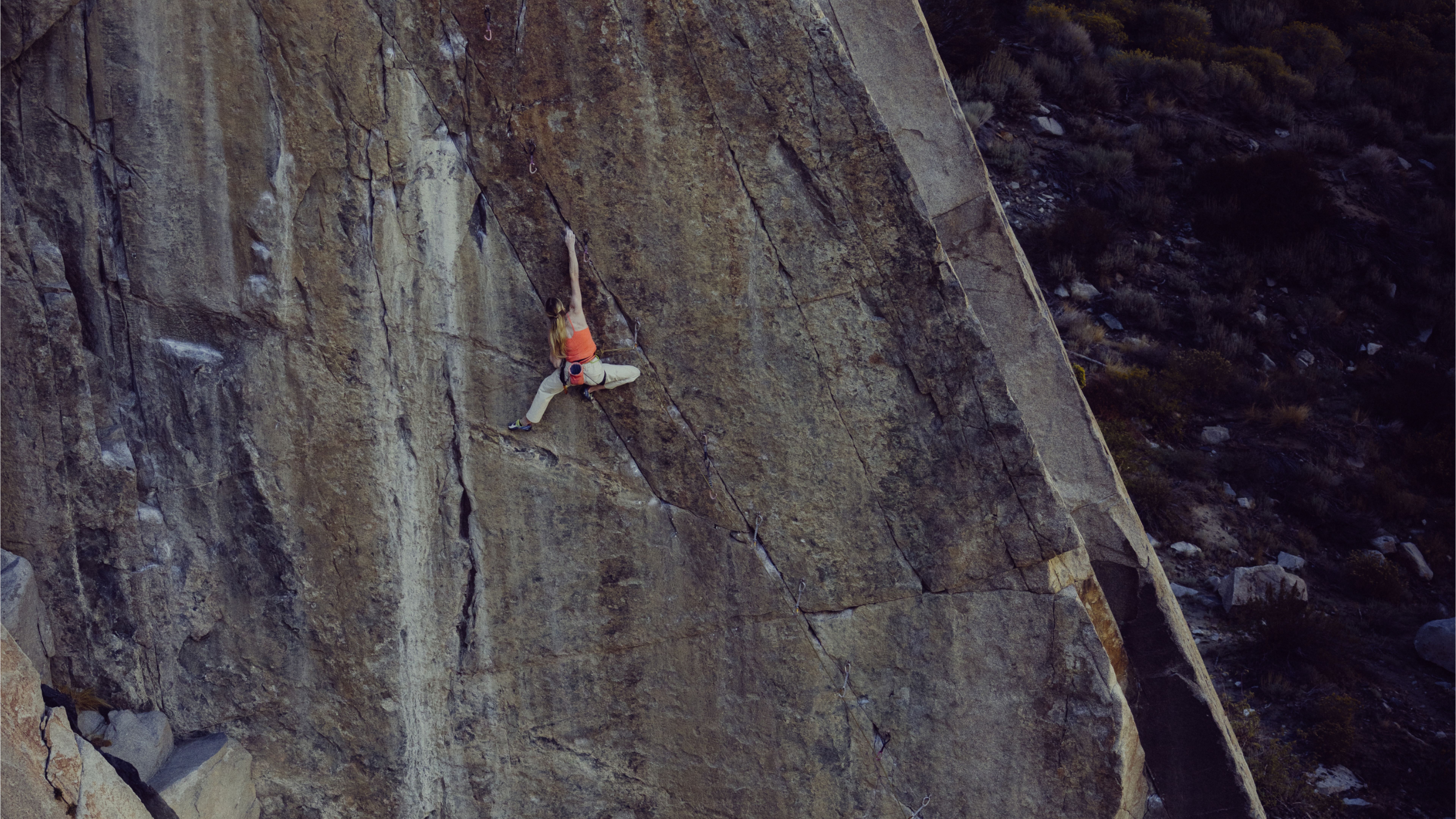 A person rock climbing a steep, textured cliff.