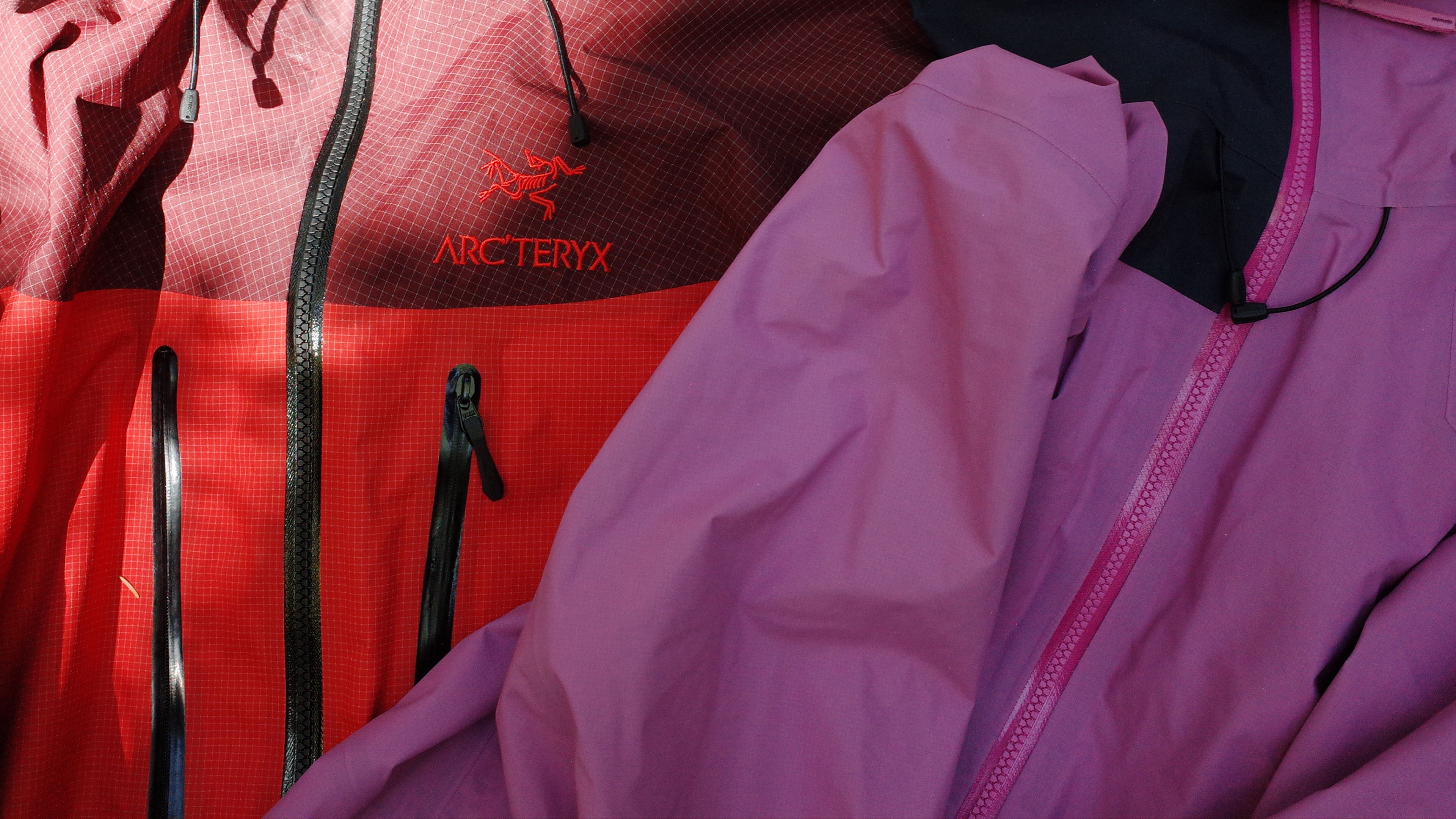 Two jackets, one red Arc'teryx and one purple, with visible zippers.