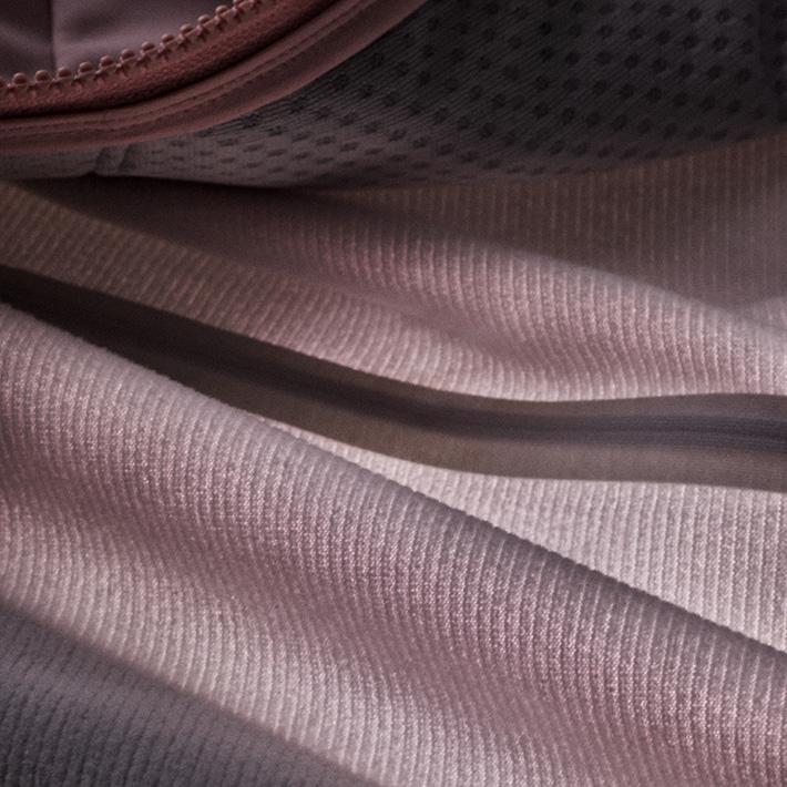 Close-up of light ribbed fabric, dark dotted mesh, and a dark seam.